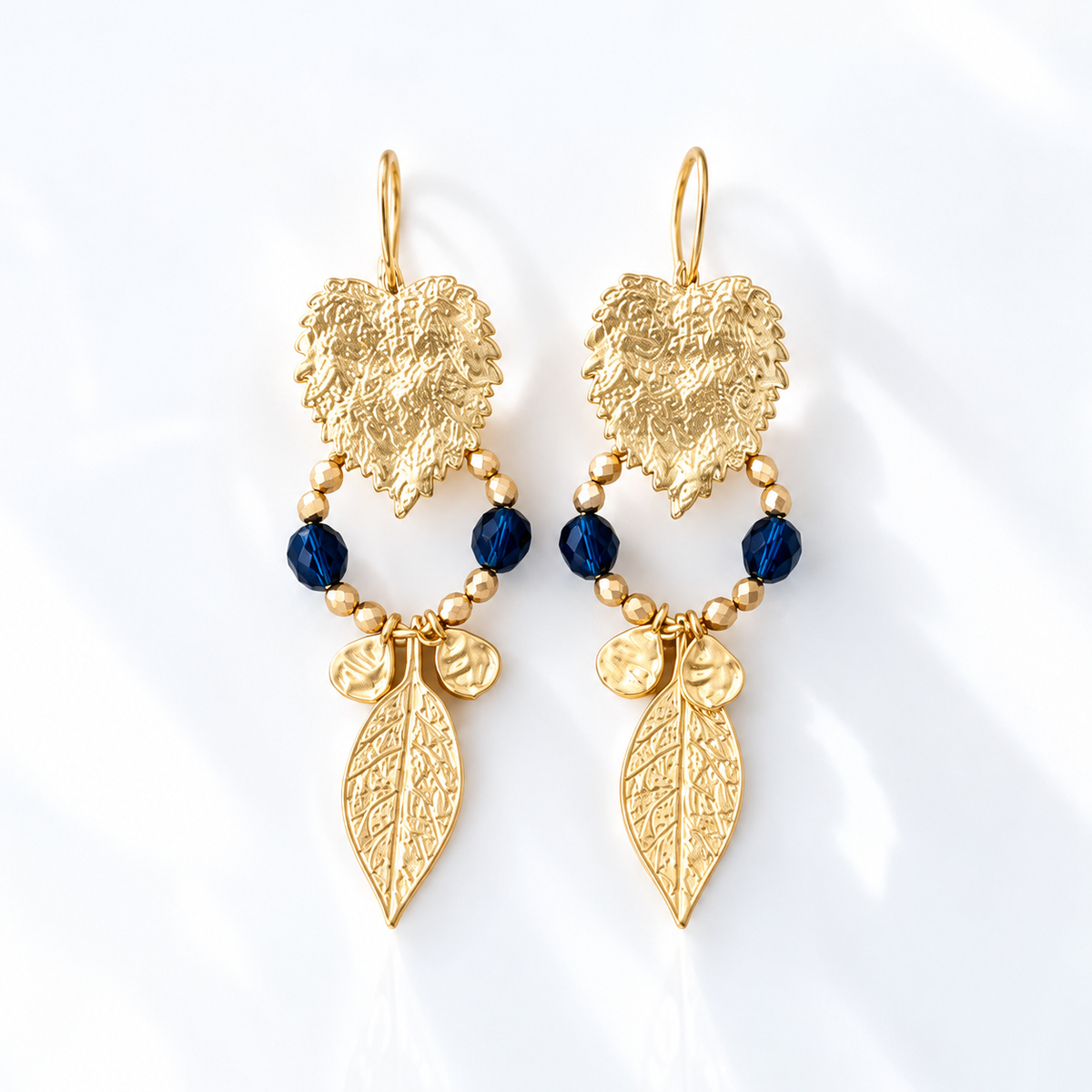Pendientes Hojas Arándanos dorados con cristales azul noche y hojas decorativas, 7 cm.

