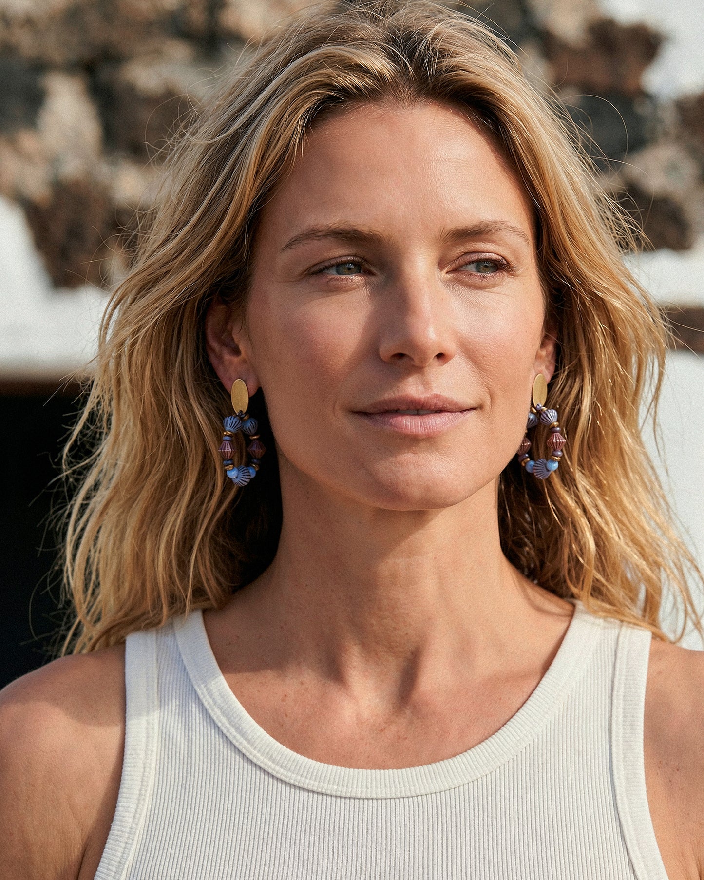 pendientes boho de aro azul y morado con cristales puestos