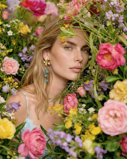 Pendientes turquesa con cadena dorada puestos en modelo look invitada
